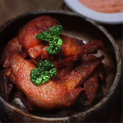 A bowl of super-hot-fiyah chicken wings garnished to perfection.